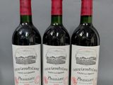 trois bouteilles de vin rouge posées sur une table