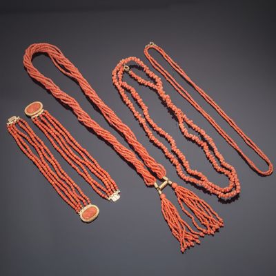 a group of coral beaded necklaces and bracelets