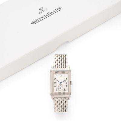une photo d'une montre-bracelet argentée posée à côté d'une boîte blanche