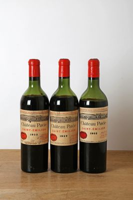 trois bouteilles de vin posées sur une table en bois, sur fond blanc