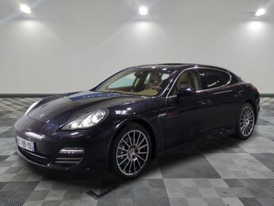 La Porsche Panamera noire est garée sur un sol en carrelage à damier.