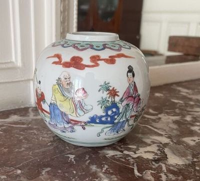 a white vase with a painting on it sitting on a table