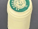 a white container with a green lid on a table