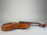 an old violin sits on a white surface with a gray background