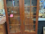 a large wooden cabinet with glass doors in a room