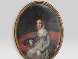 portrait d'une femme assise sur un canapé rouge