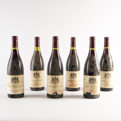 six bouteilles de vin sont alignées sur une surface blanche