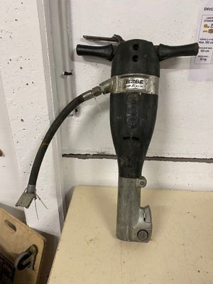 a drill with a hose attached to it sitting on a table
