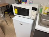 a microwave sitting on top of a refrigerator in a kitchen