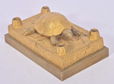 une statue en or représentant une tortue posée sur un socle