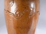 un vase brun posé sur une surface blanche