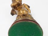 brass figurine of a baby on a green base