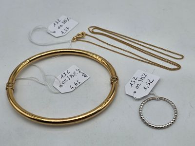 a close up of a gold bracelet and a gold bangle with a price tag