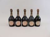 cinq bouteilles de champagne alignées les unes à côté des autres sur une surface blanche