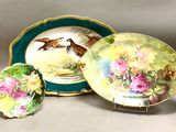 trois assiettes ornées d'oiseaux, posées sur une table
