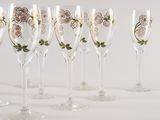 six wine glasses with floral designs are lined up on a white surface