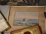 a lot of framed pictures on a table with a record