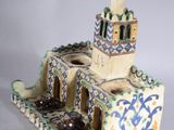 a ceramic figurine of a building with a clock tower