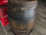 a large wooden barrel sitting on the floor next to a soda machine