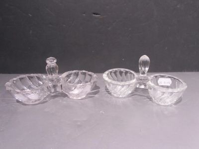 two clear glass bowls and a candle holder on a table