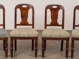 quatre chaises en bois alignées, dotées d'assises rembourrées