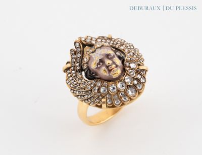 a close up of a gold ring with a face on it