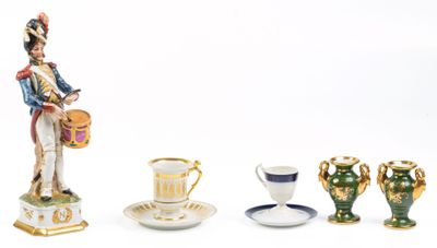 une figurine représentant un homme avec un tambour, une tasse et une soucoupe