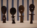 several wooden spoons are lined up on a table in front of a striped wall
