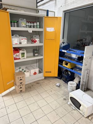 a yellow cabinet in the middle of a room with a microwave in it