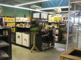 a man that is standing in a store with a bird on a cart