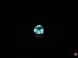 a close up of a blue diamond on a black surface