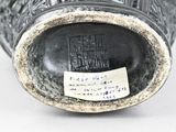 a close up of a black vase with writing on it