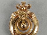 une image représentant une broche plaquée or ornée d'un motif floral