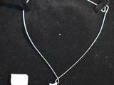 a silver necklace with a star charm on a black background