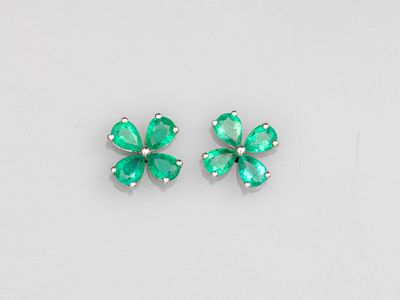 une paire de boucles d'oreilles en émeraude sur fond blanc