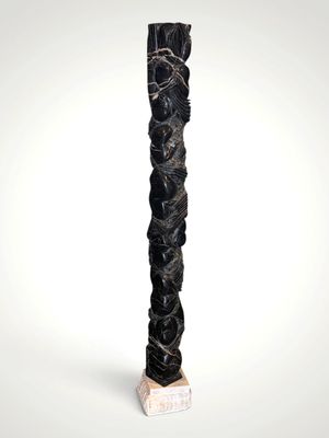 a tall black sculpture with a white base on a white surface