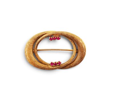 a close up of a gold brooch with pink stones