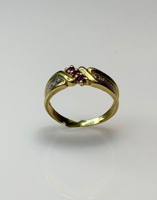 a close up of a gold ring with a ruby stone