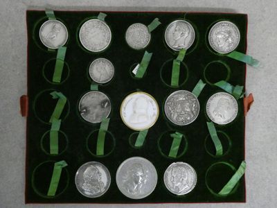 a box of silver coins with ribbons around them