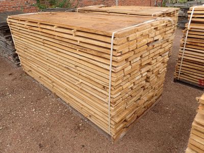 plusieurs piles de bois empilées les unes sur les autres dans une cour