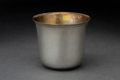 un gros plan d'une coupe en argent posée sur une surface noire
