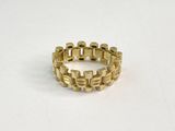 gros plan d'une bague en or sur une surface blanche