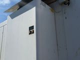 a white box on the side of a building with a sky background