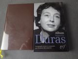 Le livre est posé sur une table, à côté d'une fleur jaune.