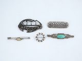 several different types of brooches and hair clips on a white surface