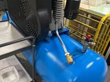 un compresseur d'air posé sur un réservoir bleu dans une usine