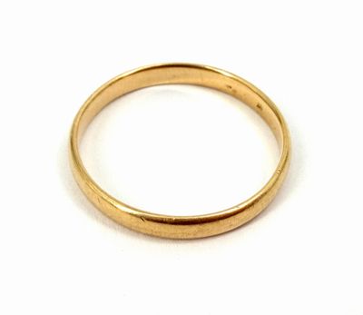gros plan d'une bague en or sur une surface blanche