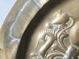 a metal plate with a lion on it on a table