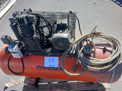 un compresseur d'air de couleur orange posé sur une palette en bois