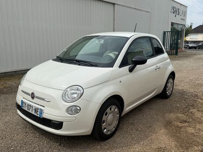 a small white car parked in front of a building